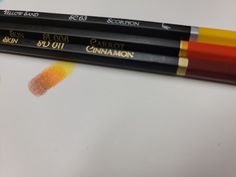 three pencils with yellow and red crayons sitting on top of each other