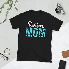 a t - shirt that says swim mom on it next to some sunglasses and other items