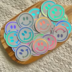 a wooden board topped with lots of different colored smiley faces