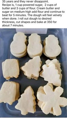 some cut up cookies are in a plastic container with white frosting on them and one cookie has been cut into smaller shapes