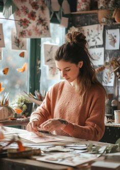 a woman sitting at a table working on paper