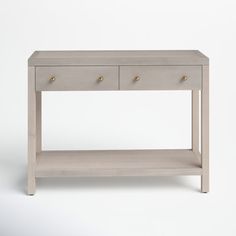 a white table with two drawers on one side and gold knobs on the other