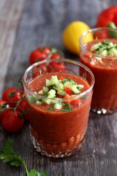 two glasses filled with tomato and cucumber garnish