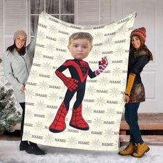 two women standing next to a blanket with the image of a spiderman on it