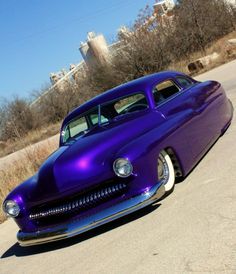 a purple classic car parked on the street