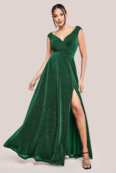 a woman wearing a green dress with thigh high slit