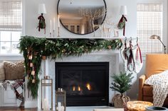 a living room filled with furniture and a fire place covered in christmas wreaths next to a fireplace