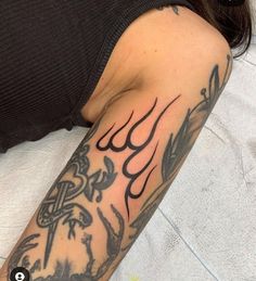 a woman with a tattoo on her arm is laying down and looking at the camera