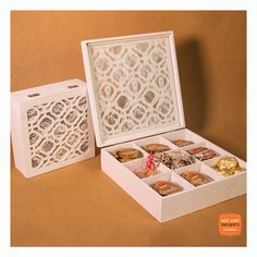 a white box with six different types of donuts in it on a brown background