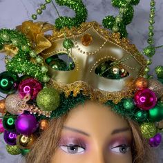 a mannequin head wearing a mardi gras mask with ornaments on it