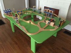 a green table with toy train tracks on it