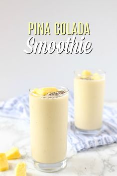 pina colada smoothie in two glasses with pineapple slices on the side