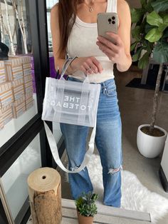 This inspired CLEAR tote bag will be the prefect accessory for all things concert, stadium events, and sporting events this summer (or any time of year). Adjustable strap Easy to clean 10.63" x 4" x 8.27" Preorder items will ship approx 14 business days from order. Trendy Mesh Bag For Daily Use, Trendy Rectangular Mesh Bags, Trendy Rectangular Mesh Bag, Casual Mesh Tote Bag, White Mesh Travel Bag, Summer White Shoulder Bag For On-the-go, Summer Mesh Shoulder Bag For Shopping, Summer Rectangular Mesh Shoulder Bag, Summer Mesh Rectangular Shoulder Bag