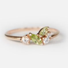 Engagement Ring Details 14k Solid Rose Gold (Also available in White and Yellow Gold, Please select at checkout) 1.5mm (Approximate Band Width) Peridot (Center Stone) Marquise 5x2.5mm (Center Stone Dimensions) 0.16 Carats (Average Center Stone Weight) Peridot (Center Stone) Marquise 4X2mm (Center Stone Dimensions) 0.09 Carats (Average Center Stone Weight) Surrounding Diamond Details White Diamonds 0.15 Carats (Total Diamond Weight/ 3 Pcs.) SI-H (White Diamond) Brilliant Cut Ring can be resized f Peridot And Diamond Ring, Peridot Wedding Ring Silver, Peridot Vintage Ring, Pearl And Peridot Ring, Aquamarine And Peridot Ring, Engagement Ring Peridot, Green Marquise Diamond Promise Ring, Peridot Ring Engagement, August Jewelry