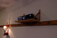 a wooden shelf with a projector on top of it