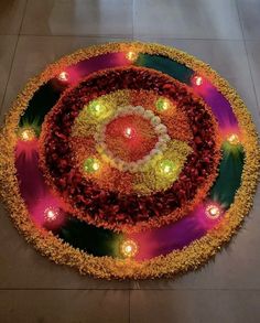 a circular arrangement of flowers and candles on the ground