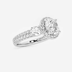 a white gold engagement ring with diamonds on the band and an oval shaped center stone