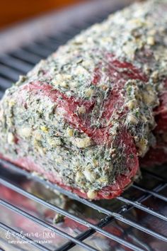 two steaks cooking on a grill with herbs and seasoning sprinkled over them