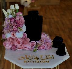 there is a cake with flowers on it and a black vase next to the cake