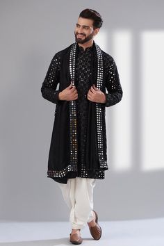 Black mandarin collar kurta with thread and mirror embroidery all over. Paired with a mirror work stole.
Components: 2
Pattern: Embroidered
Type Of Work: Mirror
Neckline: Mandarin collar
Sleeve Type: Long
Fabric: Silk
Color: Black
Other Details: 
Attached cotton lining
Note: Pant worn by the model is not for sale.
Occasion: Sangeet - Aza Fashions Black Kurta White Pajama Men, Black Mirror Work Kurta For Men, Black Mirror Kurta Men, Black Sangeet Outfit Men, Kurti Designs Latest For Men, Navratri Kurta For Men, Mens Kurta Designs Latest, Black Kurta Men, Sangeet Outfit For Men