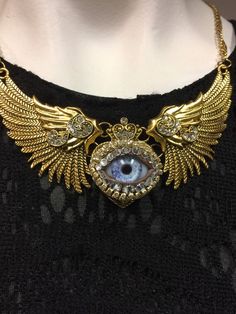 This necklace has an adjustable choker chain Heart-shaped Gold Jewelry For Festivals, Gold Fantasy Jewelry For Festivals, Heart-shaped Metal Jewelry For Festival, Gold Fantasy Necklace In Metal, Eyeball Art, Art Necklaces, Silver Wings, Blue Glass, Antique Gold