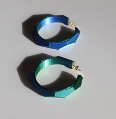 Dive into the mesmerizing world of color and shape with this Chunky Geometric Hoop Earrings. Crafted through the innovative process of 3D printing, these earrings boast a stunning iridescent blue-green hue that catches the light at every angle, ensuring you'll stand out in any crowd.  Crafted with a 3D printer and then hand finished. They measure at an impressive size (55 mm), these earrings are designed to be Lightweight for prolonged wear, so you can enjoy making a statement without sacrificin Geometric Hoop Earrings, Unique Birthday Gift, Statement Fashion, Iridescent Blue, Unique Birthday Gifts, Birthday Gift For Her, World Of Color, Jewelry Earrings Hoops, Birthday Gifts For Her