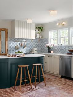 a kitchen with two stools in front of the counter