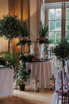 a room filled with lots of tables covered in white table cloths and flowers on top of them