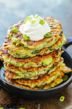 stack of zucchini fritters with sour cream on top