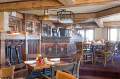 a restaurant with wooden tables and chairs in front of an old fashioned fire place oven