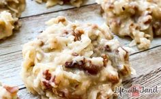 several cookies with nuts and cheese on top are sitting on a wooden table, ready to be eaten