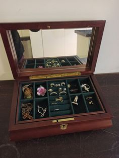 an open wooden jewelry box on a table