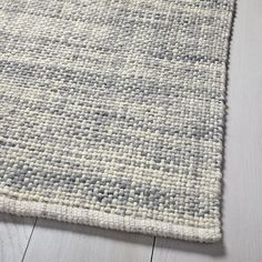 an area rug on the floor with white and gray squares patterning it's surface