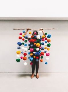 a woman holding up a bunch of pom - poms