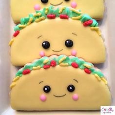 three decorated cookies in the shape of tacos