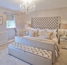 a bedroom with a large bed and chandelier