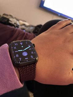 an apple watch on someone's wrist in front of a computer