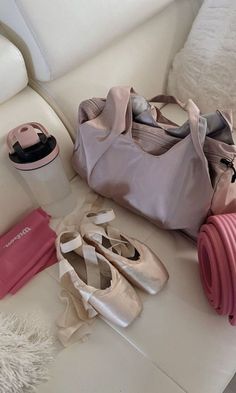 several pairs of ballet shoes are sitting on the floor next to a purse and yoga mat