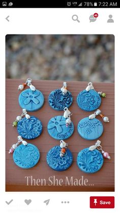 six blue buttons with charms attached to them on a piece of brown wood that says, then she made