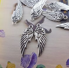 six silver angel charms sitting on top of a table