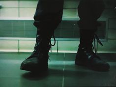 a pair of black boots sitting on top of a metal floor next to a window