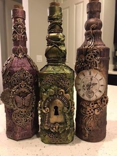 three decorative bottles sitting on top of a counter next to an open bottle with a lock