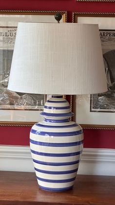 a blue and white vase sitting on top of a wooden table next to a lamp