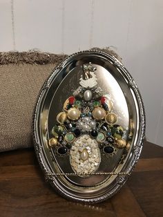 a silver tray with some ornaments on it and a pillow in the corner behind it