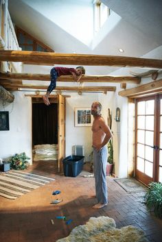 two men are standing in the middle of a room with exposed beams and wood flooring