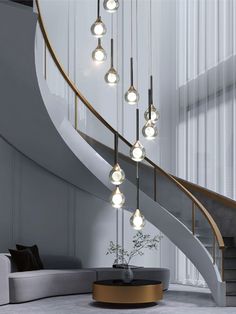 a spiral staircase with lights hanging from the ceiling and a round coffee table in front of it