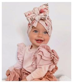 a baby girl wearing a pink dress and headband