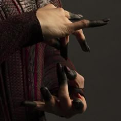 two hands with fake nails on their fingers and one holding something in the other hand