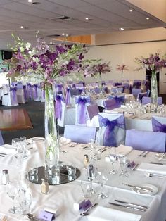 the tables are set with purple and white linens