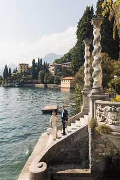 a bride and groom walking down the steps to their wedding ceremony at lake comoni